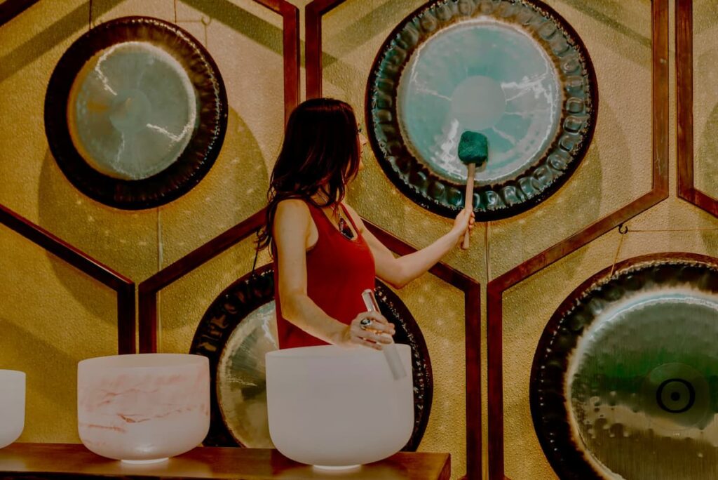 Jamie Bechtold playing gong and crystal bowl in sound bath at The Soundbath Center