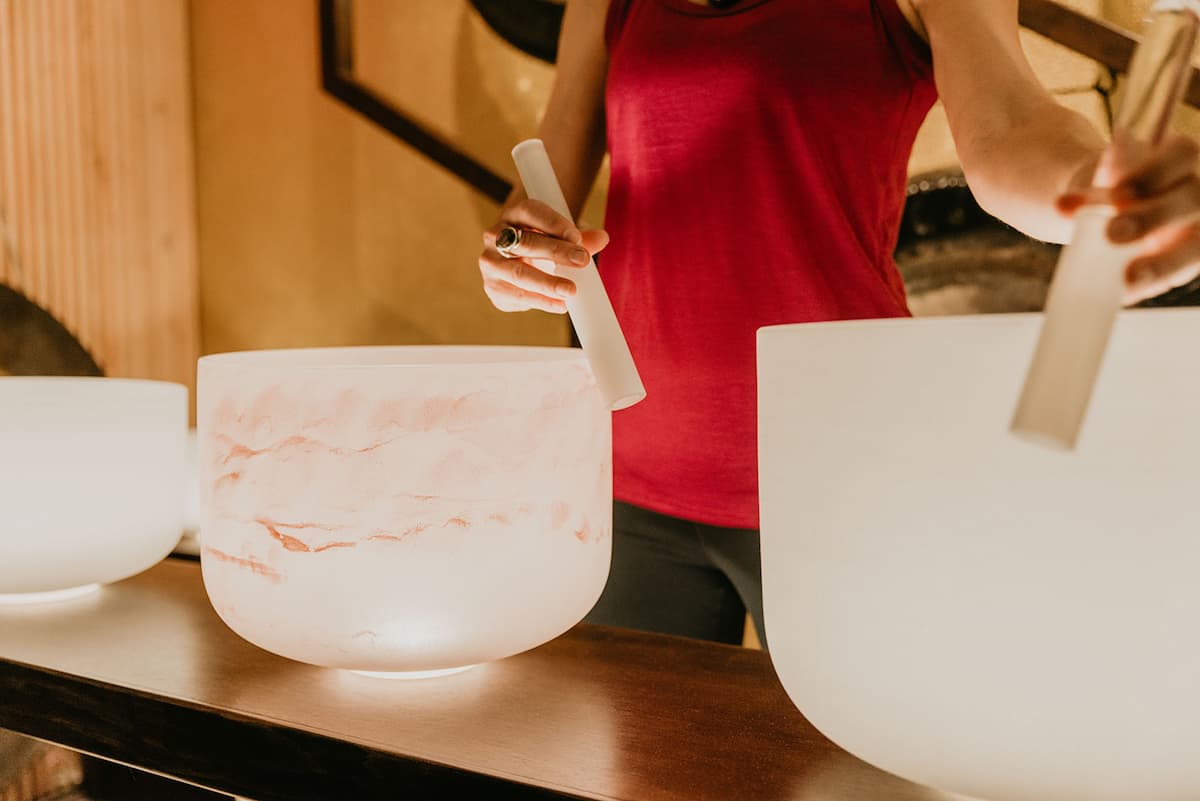 Jamie Bechtold playing two crystal bowls in sound bath training