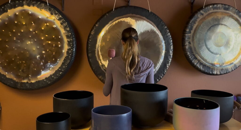 Jamie Bechtold playing Solura Alchemy gong with black crystal bowls in front